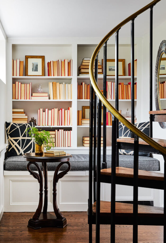 Cozy reading nook with built in shelves and seating area behind spiral staircase in luxury hotel. Cliffside Inn, Newport, Rhode Island.