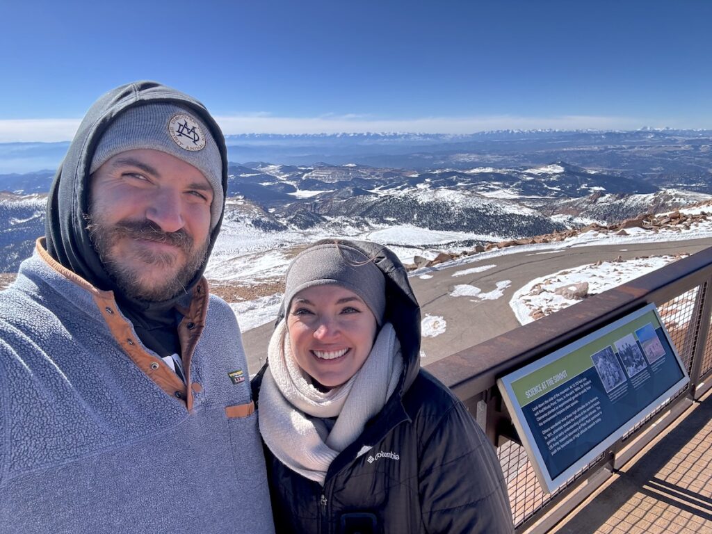 pikes peak cog railway summit in winter couple at overlook viewpoint