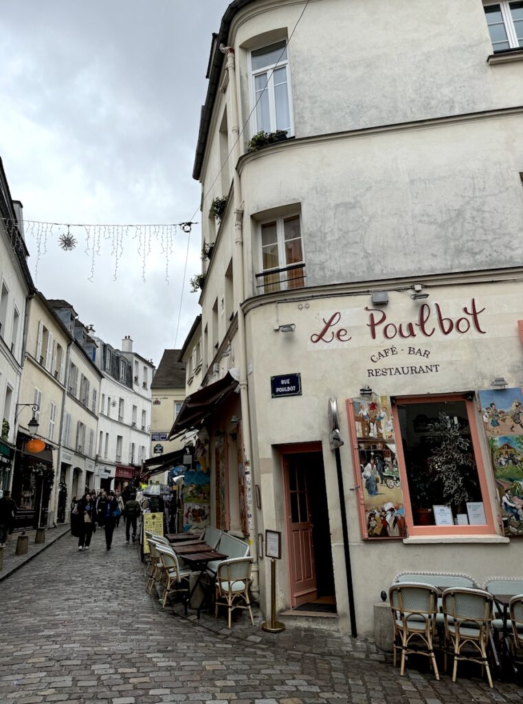 narrow cobblestone roadway and small cafe in Montmartre Paris France