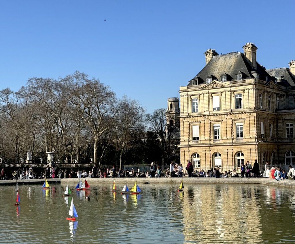 toy sailboats on pond on sunny day in Luxembourg Gardens Paris France