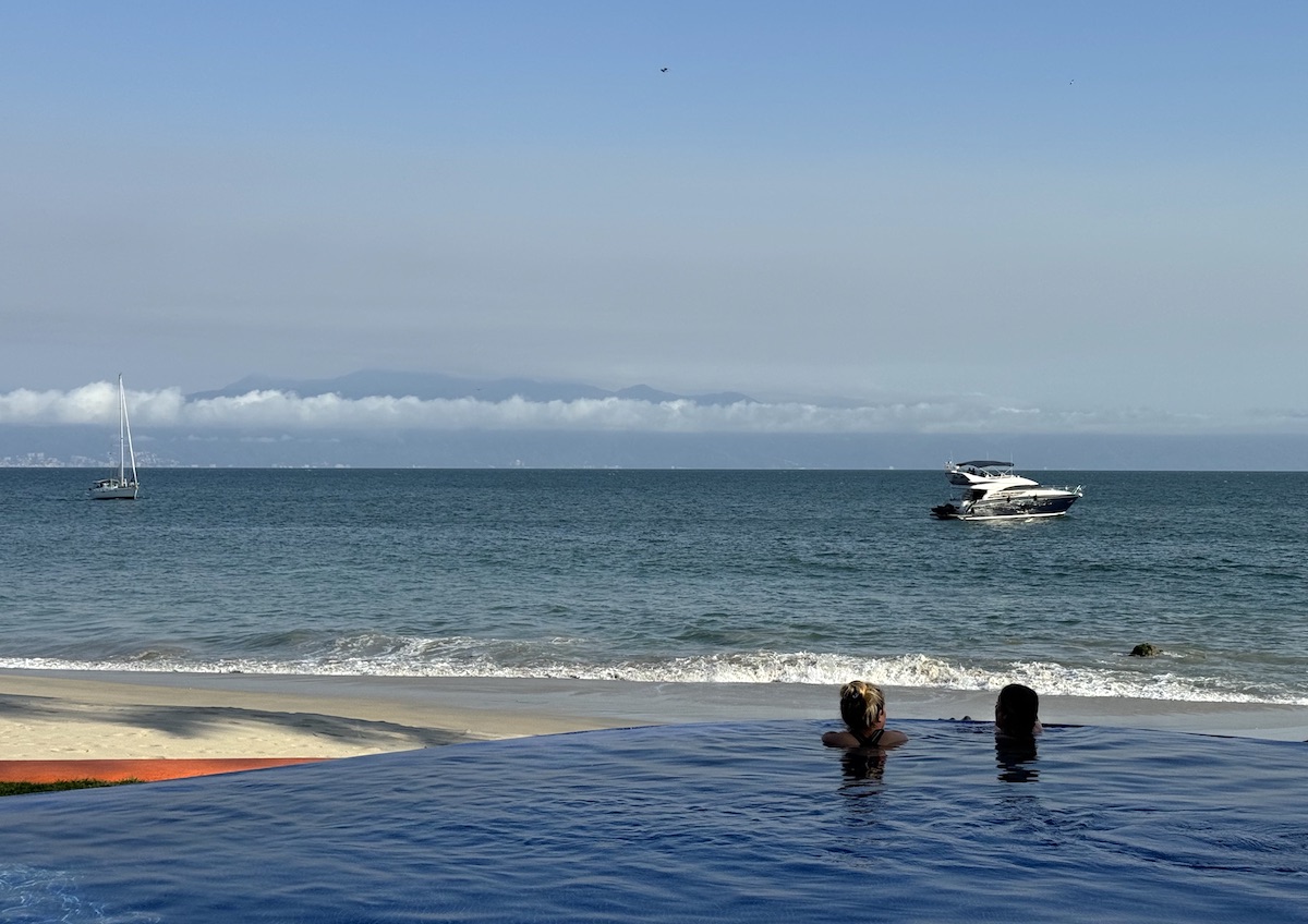 women in infinity pool overlooking ocean near puerto vallarta and punta mita