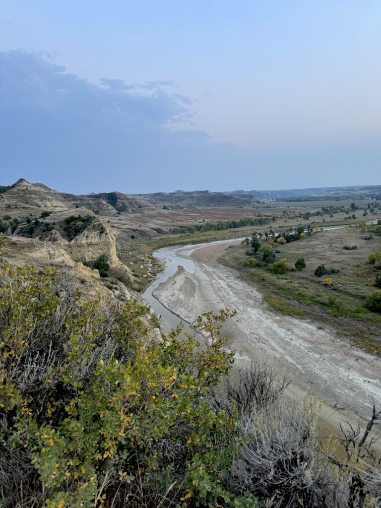 View of Little Missouri River surrounded by badlands landscape at sunset, Wind Canyon Trail, Theodore Roosevelt National Park South Unit, North Dakota.