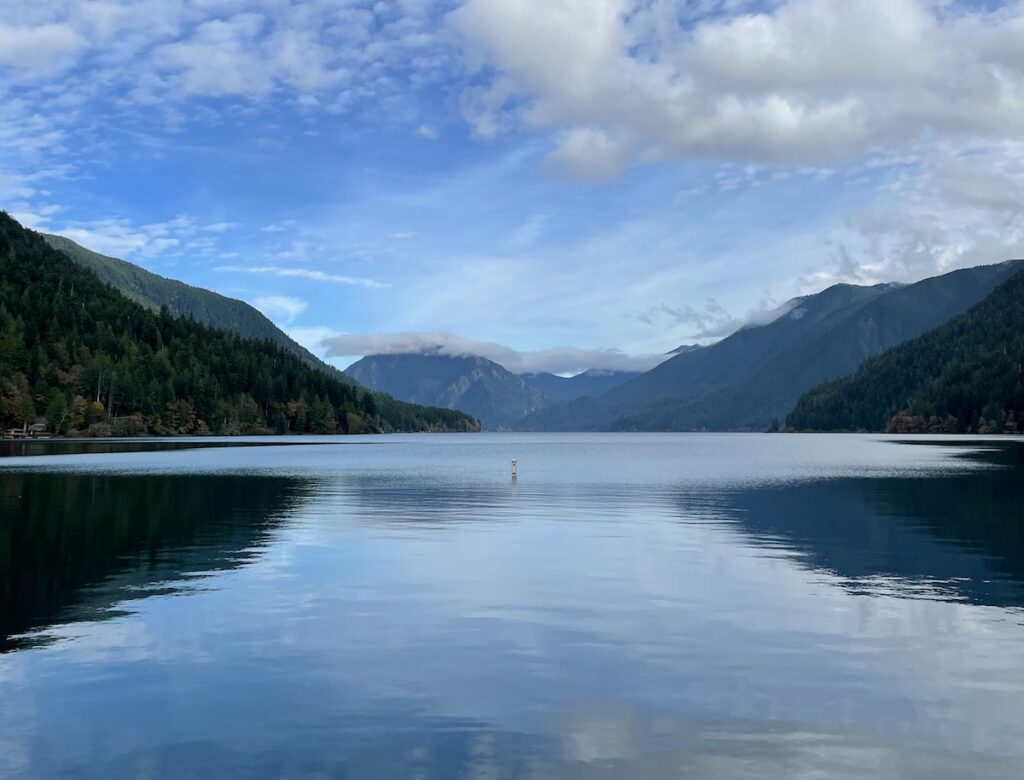 Calm lake surrounded by mountain views on sunny fall afternoon. Crescent Lake, Olympic National Park, Olympic Peninsula, Washington.