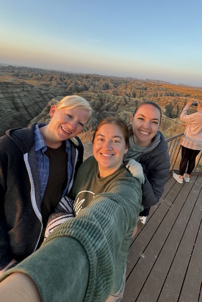 friends watching sunrise at big badlands overllok Badlands National Park South Dakota