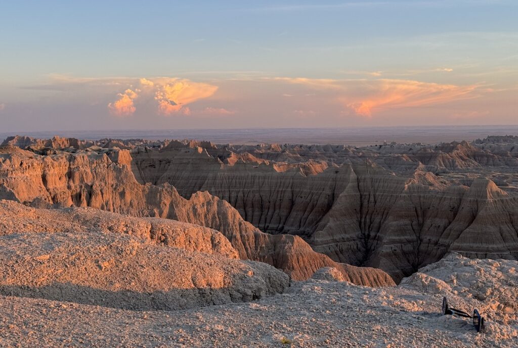 Colorful orange and purple sunset over the colorful striped badlands in Badlands National Park, Pinnacles Overlook, South Dakota.