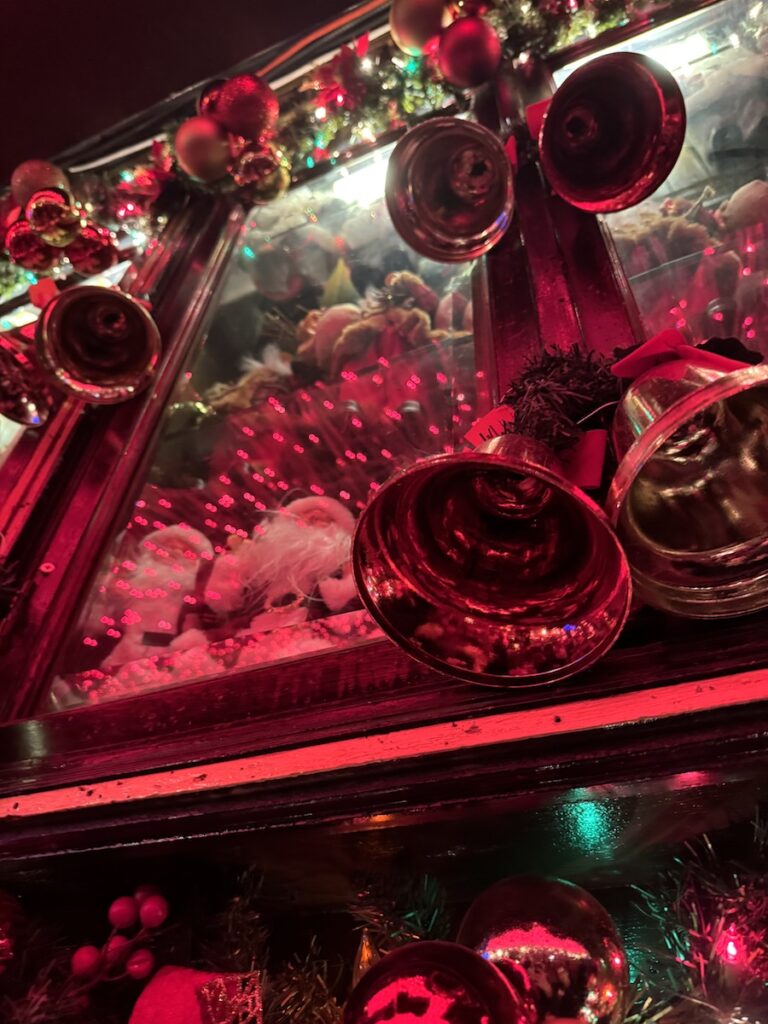 Close up of Christmas decor in bar, Santa figurines and bells all lit red. Pete's Tavern, Manhattan, New York City, New York.