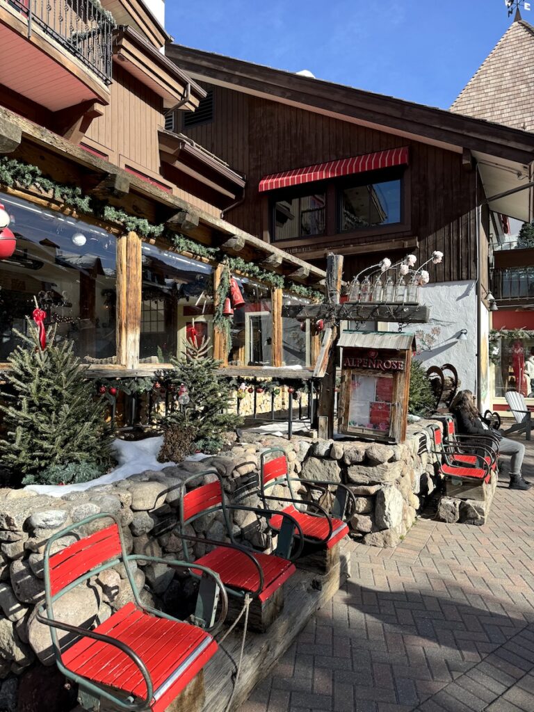 Exterior of restaurant with old ski lift chairs and mountain decor on sunny afternoon. Alpenrose, Vail, Colorado.