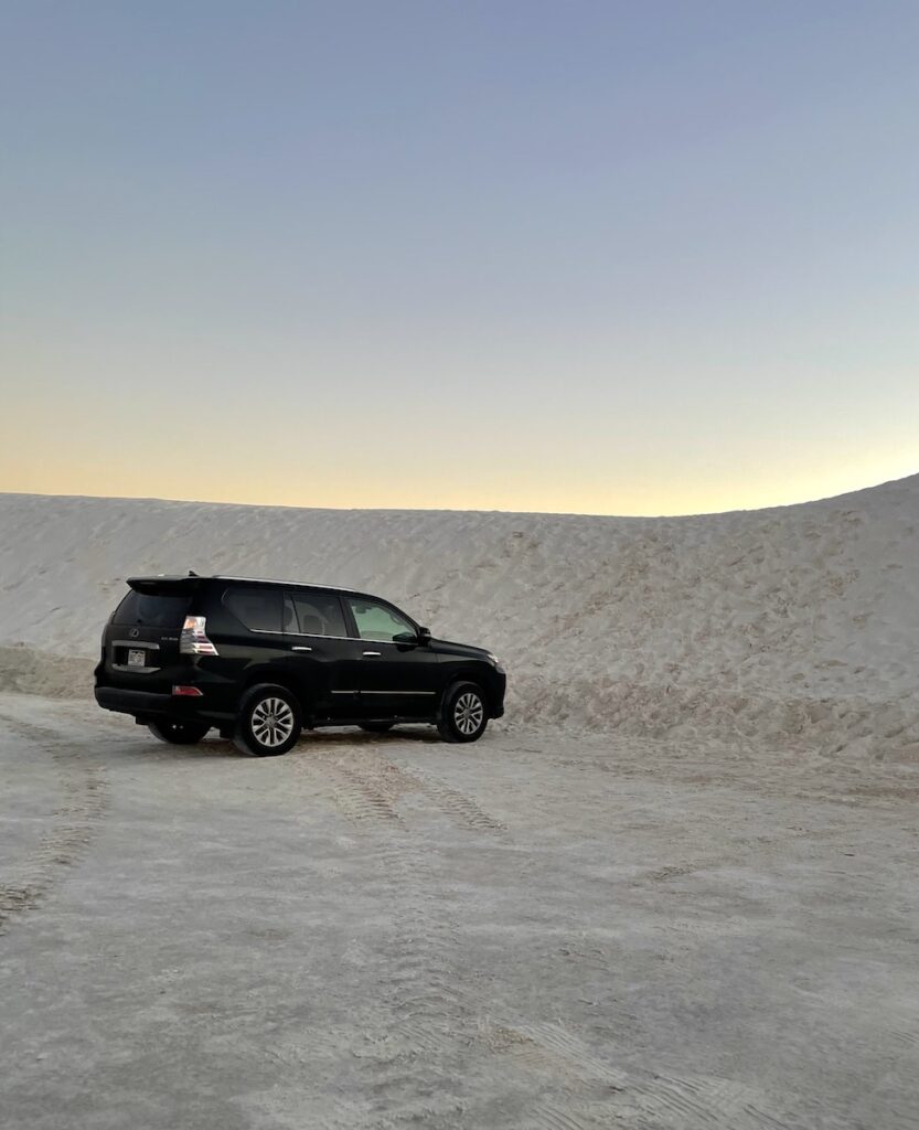 lone suv parking in sandy parking lot surrounde dy sand dunes dunes drive loop white sands national park new mexico