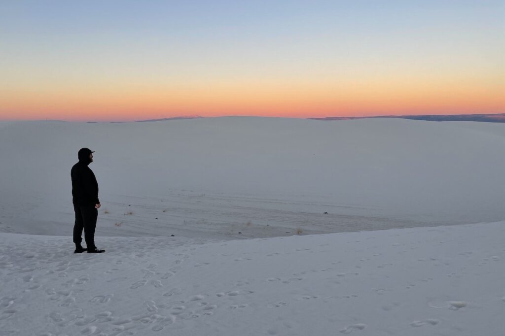 man watching pink sunset over white sand dunes alkali flat trail white sands national park new mexico