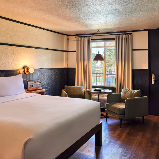 Luxury hotel guest room with queen size bed and cozy seating area. High Country Motor Lodge, Flagstaff, Arizona.