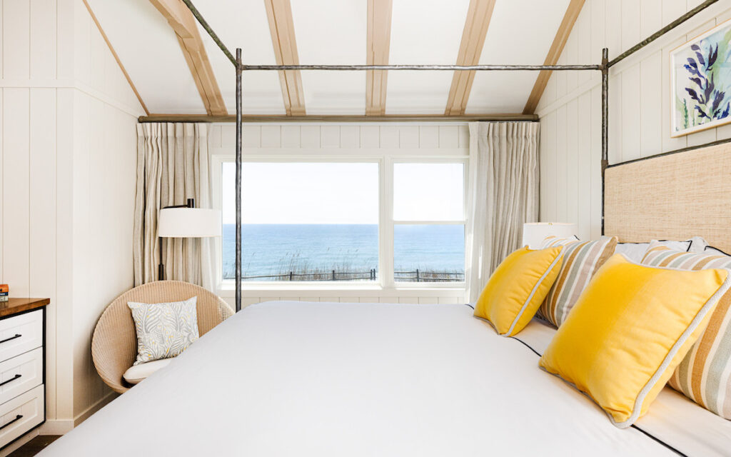 Luxury hotel room with large four poster king size bed and ocean views amid upscale beach decor. Gurney's Montauk Resort & Seawater Spa, Montauk, New York, The Hamptons