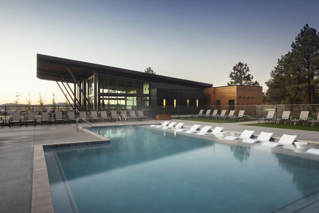 Outdoor pool and modern guest area building during sunset. Village Camp Flagstaff, Bellemont, Arizona.